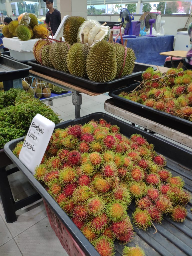 Venta de rambután en el mercado nocturno de Gadong en Brunéi