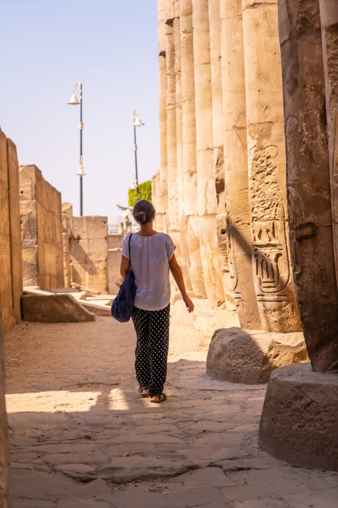 Una mujer paseando por la tarde en el templo de la diosa Hator, en Dendera.