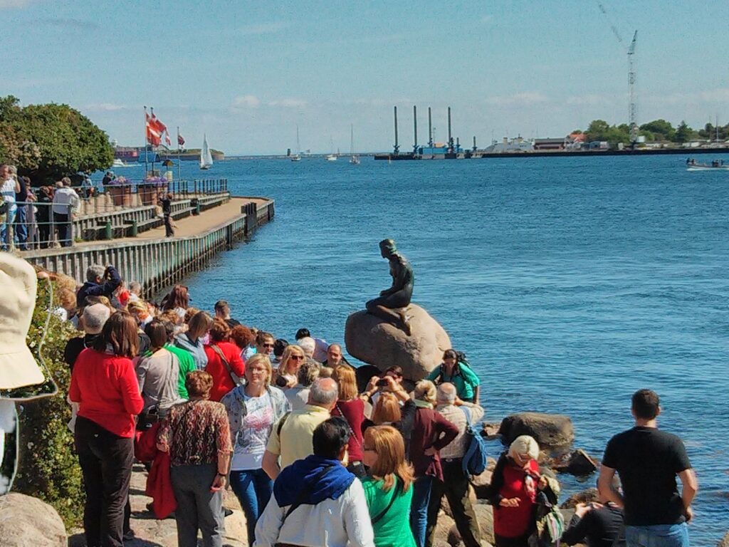 BIDtravel: tu agencia especialista en viajes organizados para grupos 2 Foto de un grupo de viajeros visitando el monumento a "la Sirenita" en Copenhague, Dinamarca